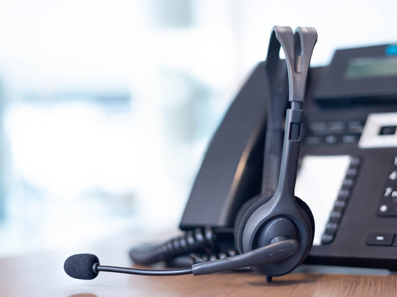 Headset und Telefon auf einem Schreibtisch im Kundendienst oder Servicecenter